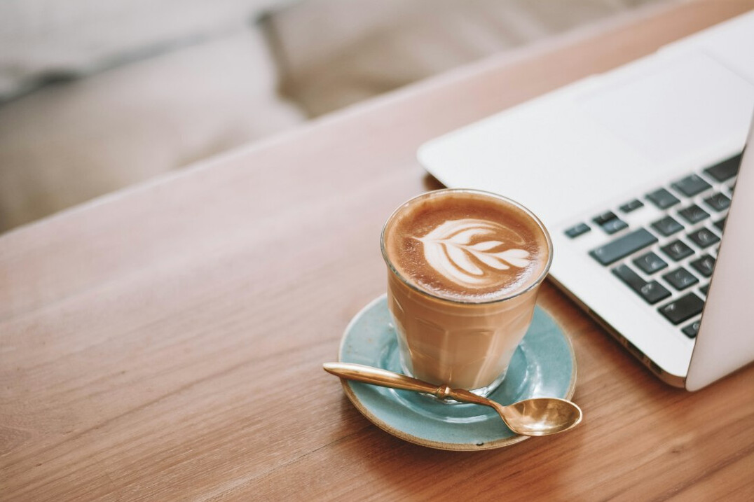 Laptop, notebook and coffee cup arranged on a desk